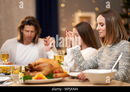 Beautiful family praying over festive dinner at home Stock Photo