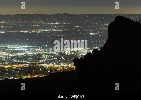 Predawn view across the San Fernando Valley with Santa Susana Mountains rock outcropping silhouette in Los Angeles, California. Stock Photo