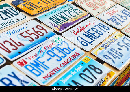 Old discontinued car license plates or vehicle registration numbers from different USA states such as California, Illinois, Nevada, Texas, Arizona. Stock Photo