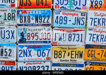 Old discontinued car license plates or vehicle registration numbers from different USA states such as California, Texas, Oklahoma, South Dakota Stock Photo