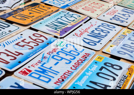 Old discontinued car license plates or vehicle registration numbers from different USA states such as California, Illinois, Nevada, Texas, Arizona. Stock Photo