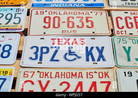 Old discontinued car license plates or vehicle registration numbers from different USA states such as Texas, Oklahoma, Indiana. Stock Photo