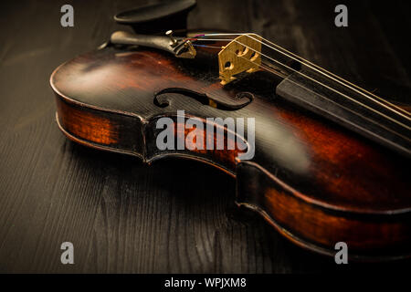 Close view of old violin and strings in vintage style on wood background Stock Photo