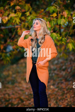 Cozy outfit ideas for weekend. Woman walk sunset light. Clothing for every  day. Cozy casual outfits for fall. Girl adorable blonde posing in warm and  cozy outfit autumn nature background defocused Stock