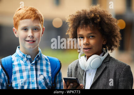 Portrait of two friends African and Caucasian ethnicity smiling at camera while spending time outdoors Stock Photo