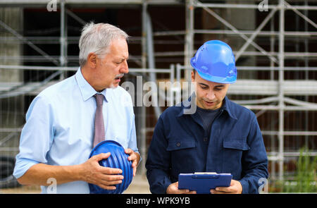 Two architect developers reviewing building plans at construction site Stock Photo