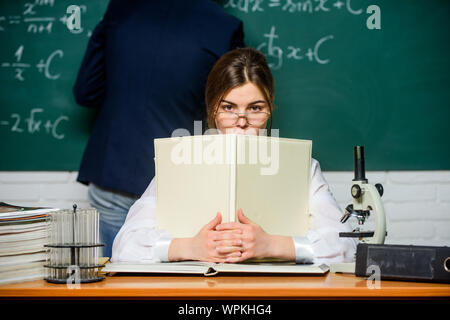 Teaching in university. High school. University education. Knowledge transfer. Teacher and student near chalkboard. College university education. STEM faculty. Man writing on chalkboard math formulas. Stock Photo