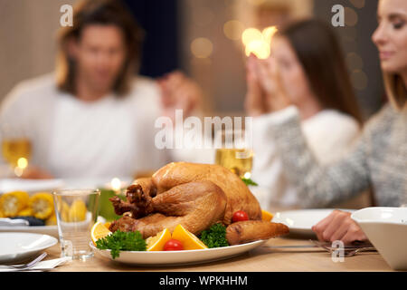 Beautiful family praying over festive dinner at home Stock Photo