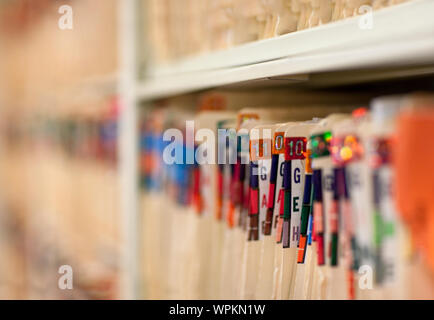 Close-up of folders sorted on the shelf in hospital office. Stock Photo