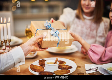 Hanukkah dinner. Family gathered around the table with traditional dishes Stock Photo