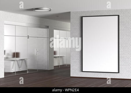 Large blank vertical poster on the white brick wall in modern office Stock Photo