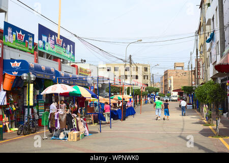 LIMA, PERU - FEBRUARY 13, 2012: Unidentified people on the street Narciso de la Colina with some household supply stores at market hall Stock Photo