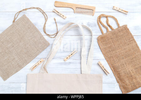 Fabric bag and wooden clothes pegs on white wooden background. Zero waste Stock Photo