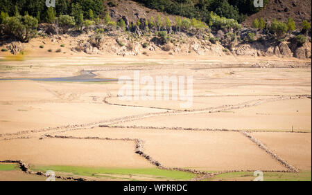 A reservoir late in the growing season, drained of water. Stock Photo