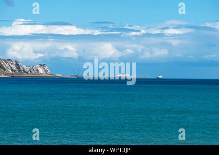 View from Folkestone Harbour across the bay to the distant port of Dover, Kent, UK Stock Photo