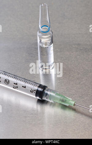 Close-up of glass medication ampule and filter needle with syringe. Stock Photo