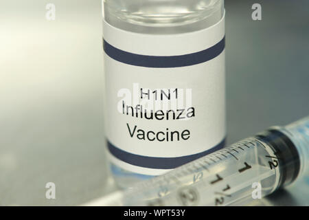 H1N1 Influenza Virus Vaccine on silver tray with syringe. Stock Photo