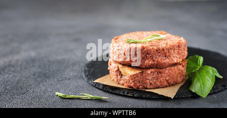 Two raw vegan patties on dark grey background. Copy space Stock Photo