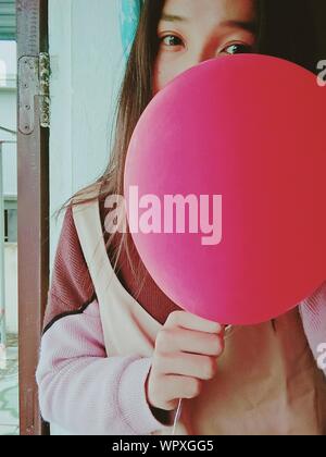 Portrait Of Young Woman Holding Pink Balloon