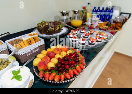 Healthy fruit platter, strawberries cherries oranges peaches apples apricots on the table, close up. Stock Photo