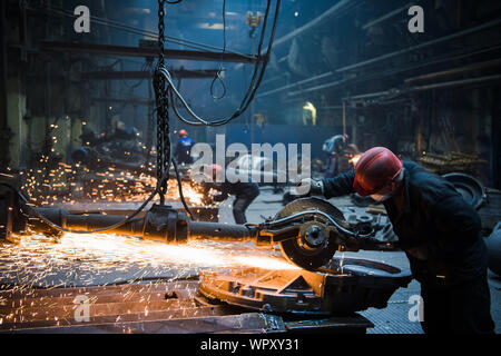 Welder used grinding stone on steel in factory with sparks. Stock Photo