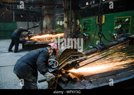 NIZHNY NOVGOROD, RUSSIA - OCT 7, 2017: Industrial workers with work tool. Big chainsaw in hands at steel factory Stock Photo