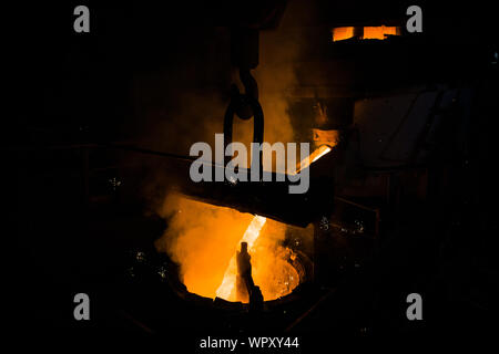 Foundry - molten metal poured from ladle into mould - lost wax casting. Stock Photo