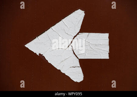 A weathered peeling arrow directional sign on a road side in Speculator, NY USA Stock Photo