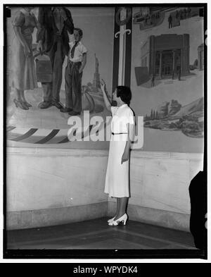 Many errors found in Department of Justice mural. Washington, D.C., Aug. 17. Aides of Attorney General Cummings are taking great delight these days in criticizing the realism of several of the murals which [...] Boughe[?], New York artist painted for the new Department of Justice building. Miss Margaret Burgess, a sightseer, points to the Statue of Liberty which was painted facing shoreward instead of seaward other glaring errors showed a convict facing four members of the Federal Court of Parole, although actually he faces only one in real life, a fire starting in a large city, although Feder Stock Photo