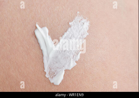 Check sign from white skin cream on clean beige color background Stock Photo
