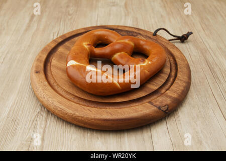 pretzel German bread on wood plate closeup isolated on table Stock Photo