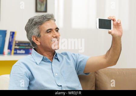 Senior man taking picture of himself with a mobile phone Stock Photo