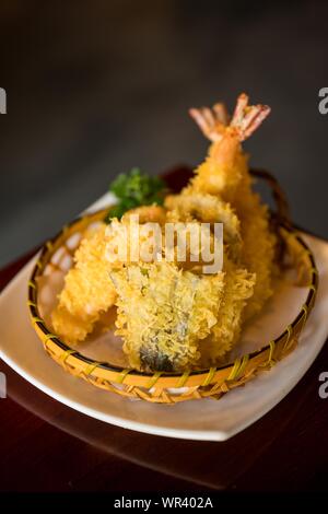 Vertical shot of a dish with noodles in the basket on a white plate with a blurred background Stock Photo