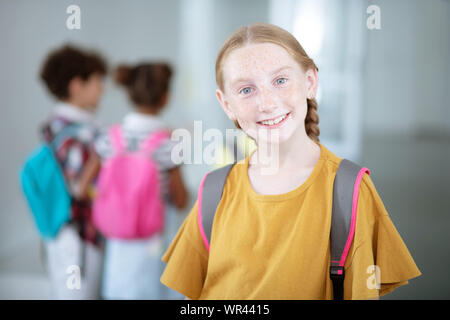 Girl smiling broadly while feeling good at school Stock Photo