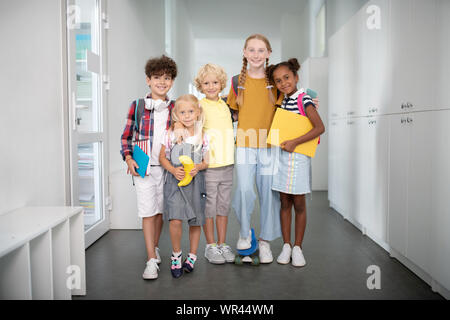 Friendly pleasant pupils hugging each other Stock Photo