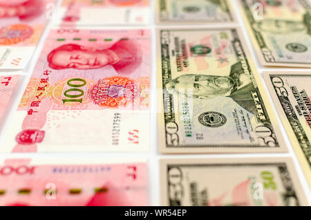 Flat laying US 50 dollar and Chinese 100 Yuan notes. Photo with selective focus. Stock Photo