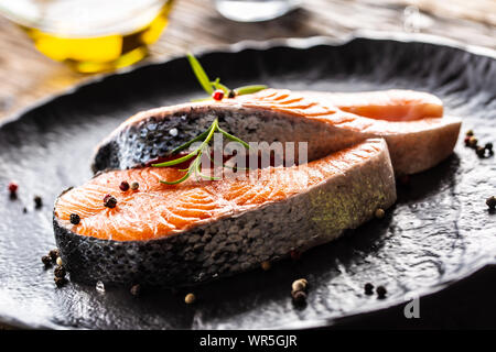 Salmon raw steaks rosemary tomatoes mushroom lime olive oil and spices. Stock Photo