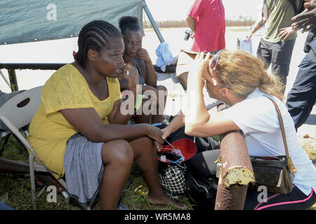 Treasure Cay, The Bahamas. 9th Sep 2019. Broward County business woman, Christina Henley comforts Sherrine LeFrance at Treasure Cay in the Bahamas on September 9, 2019. Henley was responsible for Logistics support in assuring the delivery of consumable and medical products to the island. The stop on Treasure Cay, The Bahamas was conducted to provide consumable and medical products to the local population. Credit: UPI/Alamy Live News Stock Photo