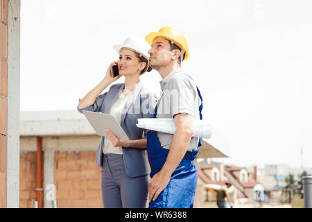 Project developer and construction worker on site using technology Stock Photo