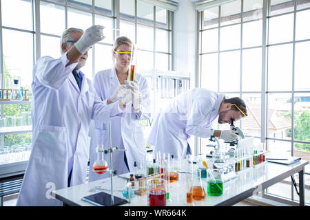 Medical Research and Scientists are working with a microscope and a tablet and Test Tubes, Micropipette and Analysis Results in a laboratory. Stock Photo