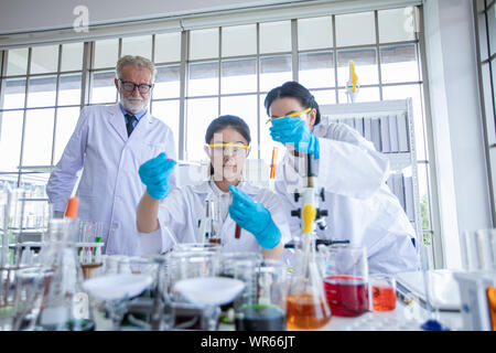 Medical Research and Scientists are working with a microscope and a tablet and Test Tubes, Micropipette and Analysis Results in a laboratory. Stock Photo
