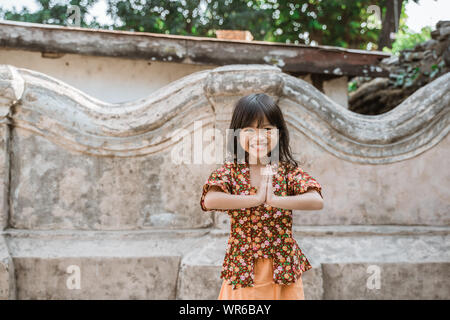 Happy little girl greeting in traditional way from indonesia Stock Photo