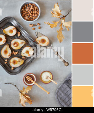 Color matching palette from image with baked pears and caramelized nuts on gray concrete background decorated with Autumn leaves Stock Photo