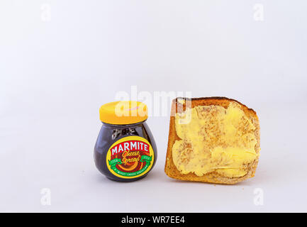 Johannesburg, South Africa - a jar of Marmite breakfast spread isolated next to a slice of buttered toast on a white background image with copy space Stock Photo
