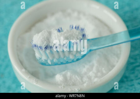 Close-up of baking soda in a bowl with a toothbrush - Teeth whitening Stock Photo