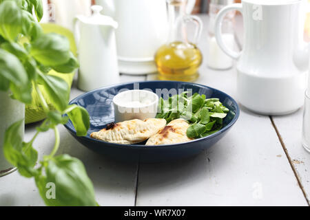 Appetizer. Crunchy stuffed calzone with garlic yoghurt sauce. Stock Photo