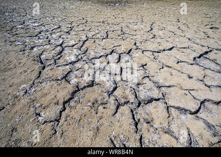 Dry lake bed with natural texture of cracked clay in perspective floor. Death Valley field . background. Selective focus on black soil dark land. Idea Stock Photo