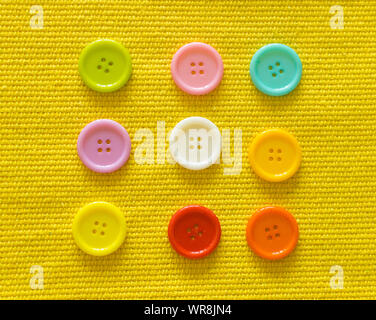 Various sewing buttons  on yellow background. Stock Photo