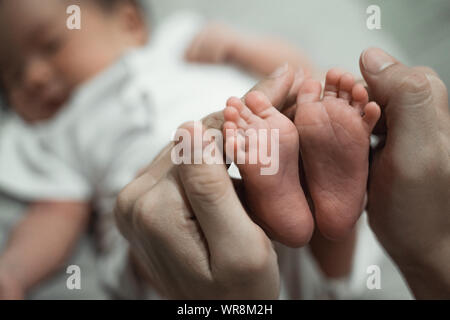 Mother hands holding baby feet Stock Photo