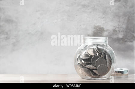 Glass piggy bank saving money concept,and a coins Stock Photo